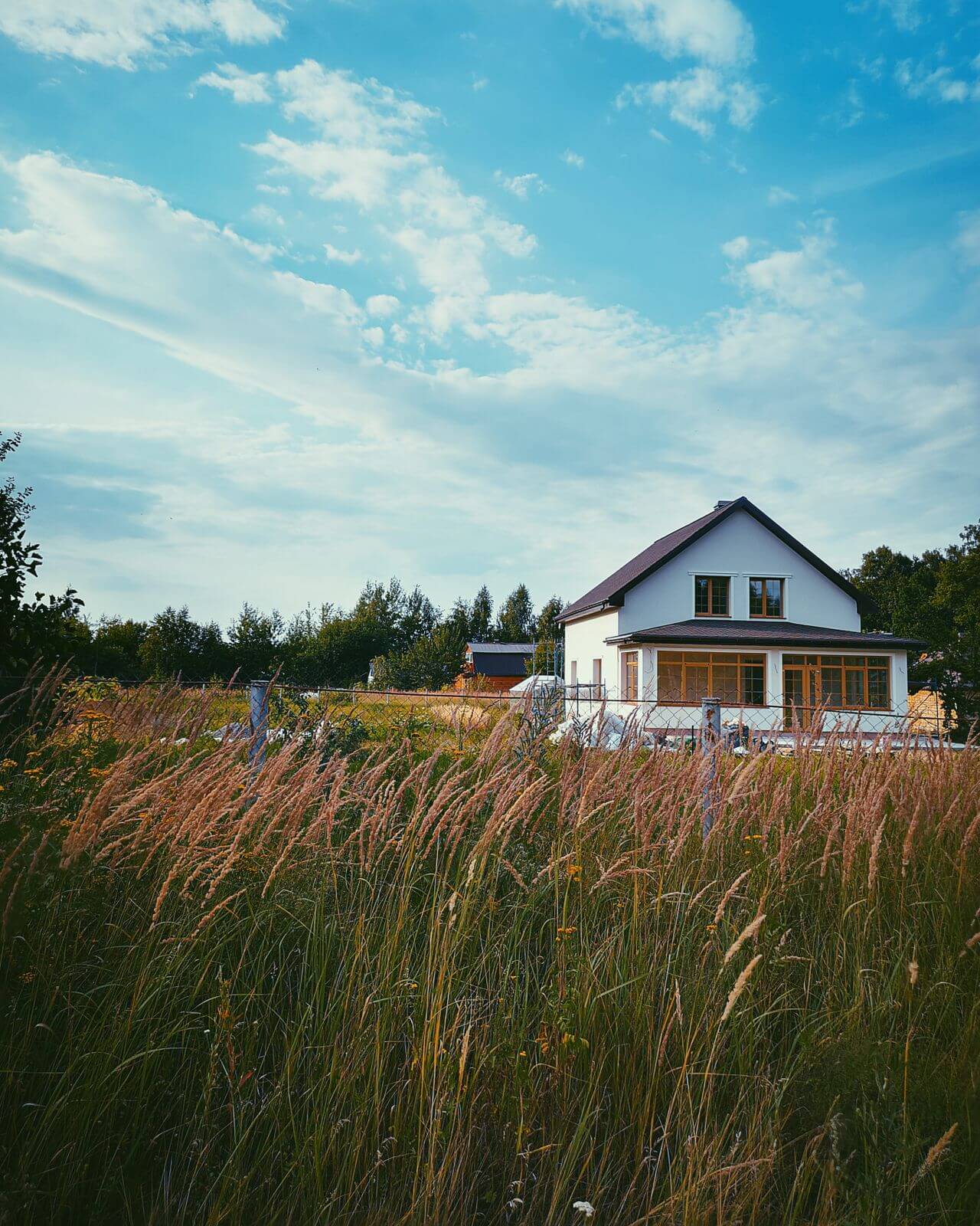 Exterior view of a 480 sq ft backyard cottage and detached ADU in Wheat Ridge, Colorado set against a bright blue sky.
