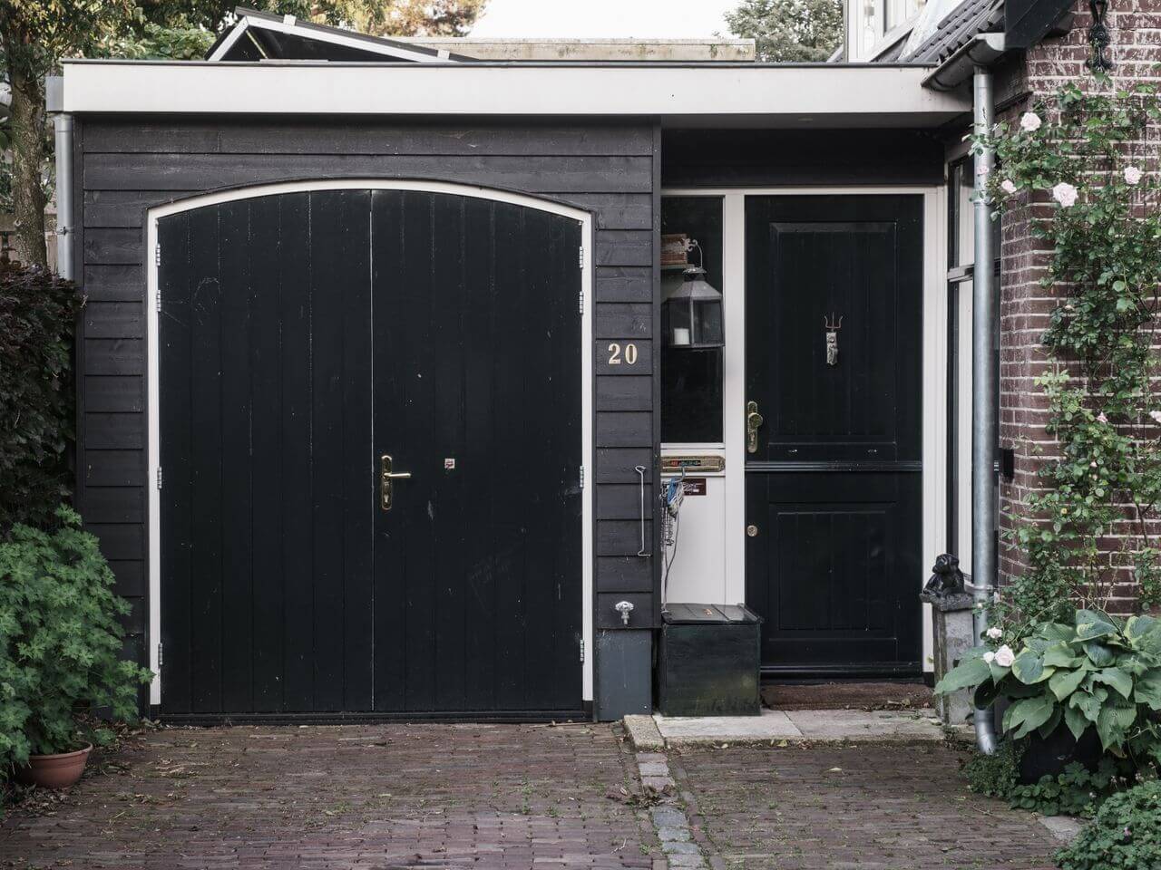 Black wood-clad garage conversion exterior with custom doors and historic architectural styling for a Colorado ADU design guide.