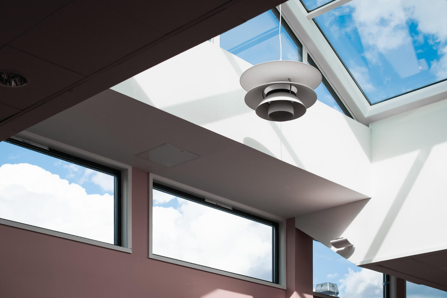Interior view of skylights, light wells, and large windows bringing natural sunlight into a below-grade basement accessory dwelling unit.